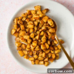 Mastering Steak Sides: 20+ Perfect Pairings and Pitfalls 2 Crispy golden oven roasted potatoes on a white plate, ready to serve with steak.