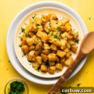 Mastering Steak Sides: 20+ Perfect Pairings and Pitfalls 8 Crispy sous vide potatoes on a plate garnished with parsley, next to a wooden spoon.