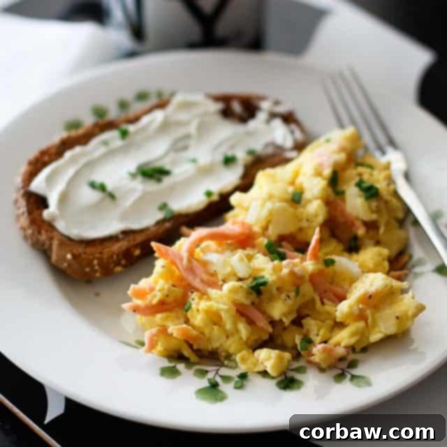 Deluxe Salmon Scramble 2 Delicious Smoked Salmon Scrambled Eggs ready to be served on a plate with fresh greens.
