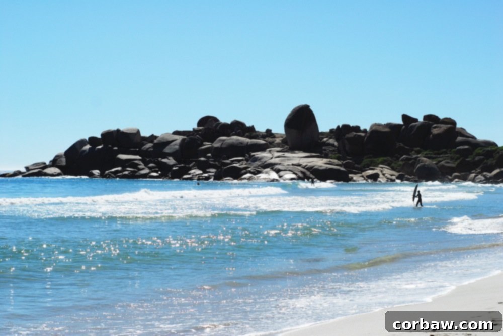 A Cape Town beach featuring immense granite boulders scattered along the shoreline.