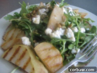 Mixed greens salad with grilled pears and goat cheese on a plate
