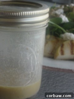 Close up of a mixed greens salad with grilled pears, goat cheese, and pumpkin seeds