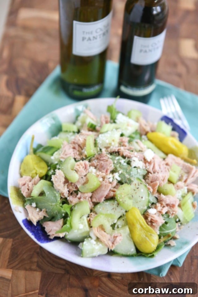 Nutritious Mediterranean Chopped Tuna Salad A vibrant bowl of greens generously topped with flaky tuna, crisp cucumbers, fresh celery, and colorful bell peppers, all lightly sprinkled with feta cheese. A perfect Mediterranean Chopped Tuna Salad.