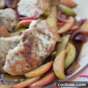 Hard cider pork chops with apples and onions served in a skillet, showcasing the succulent pork and caramelized fruit.