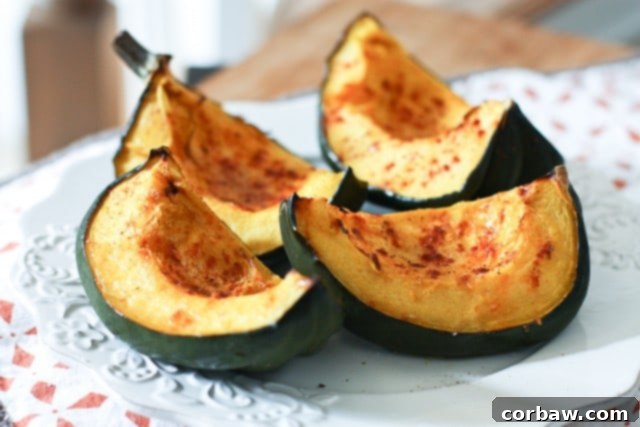 close-up view of perfectly roasted acorn squash wedges on a white plate, garnished and ready to serve