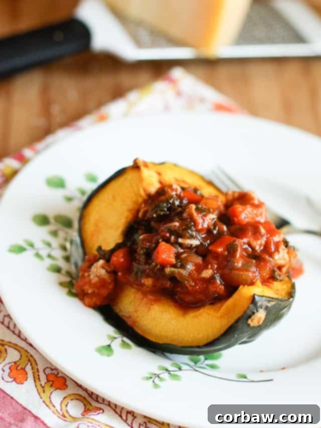 A warm bowl of Roasted Acorn Squash Bolognese, featuring tender roasted squash halves topped with a rich, savory turkey and kale bolognese sauce, perfect for a healthy low-carb winter dinner.