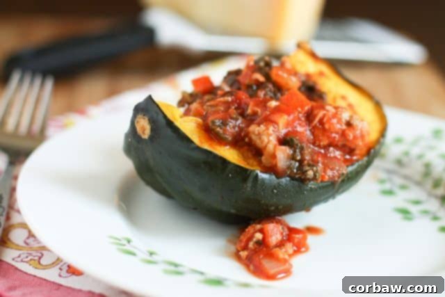 Close-up of Roasted Acorn Squash Bolognese, showcasing the rich texture of the turkey and kale bolognese nestled inside a perfectly roasted acorn squash half, ready to be enjoyed as a wholesome meal.