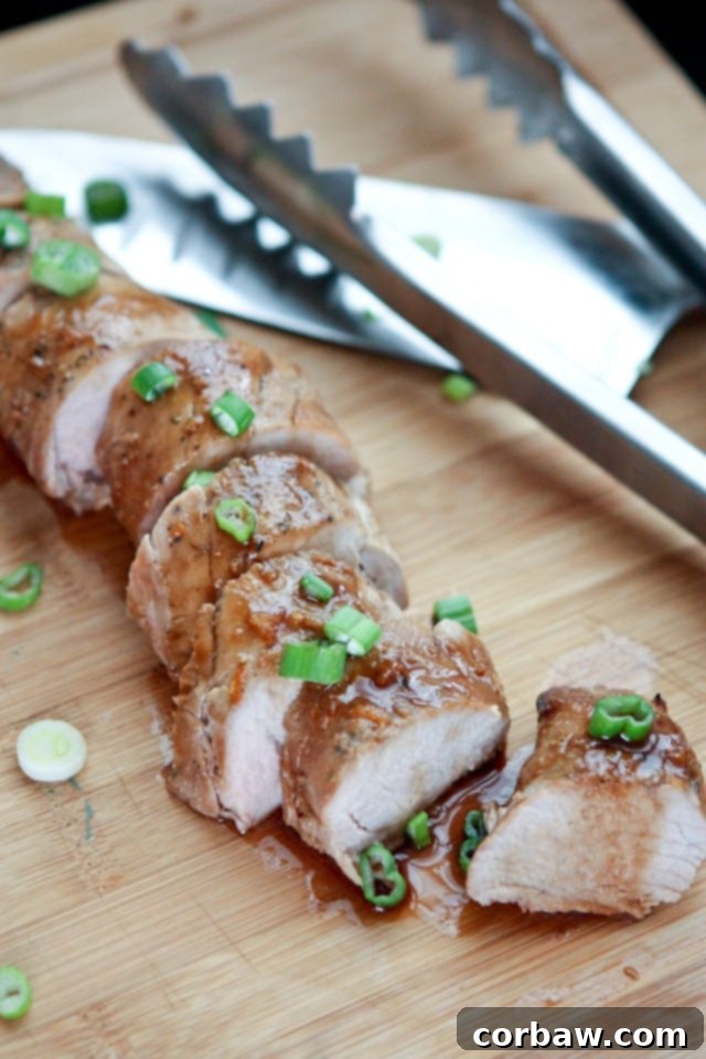 Easy Slow Cooker Asian Citrus Pork Tenderloin Recipe A beautifully cooked Slow Cooker Asian Citrus Pork Tenderloin, sliced and garnished with fresh scallions, ready to serve with rice and vegetables.