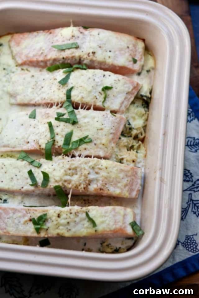 Salmon Spinach Bake from Sugar-Free Mom baking contained with salmon topped with a creamy sauce and green garnish