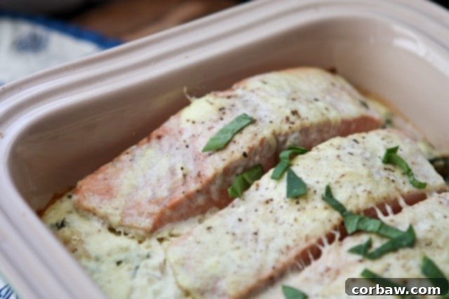Salmon Spinach Bake from Sugar-Free Mom baking container with salmon topped with a creamy sauce and green garnish
