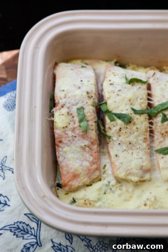 Salmon Spinach Bake from Sugar-Free Mom baking container with salmon topped with a creamy sauce and green garnish
