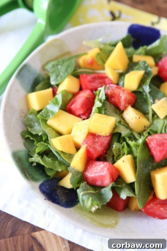 Bright and refreshing Green Mango Salad with sliced unripe mango, tomatoes, and mixed greens, drizzled with lime juice and seasoned with coarse salt and pepper.