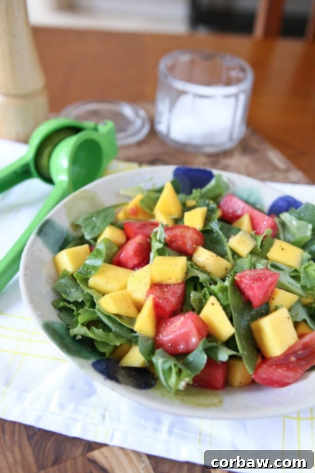 Close-up of a refreshing Green Mango Salad, featuring thin slices of unripe mango, red tomatoes, and fresh greens, beautifully presented.