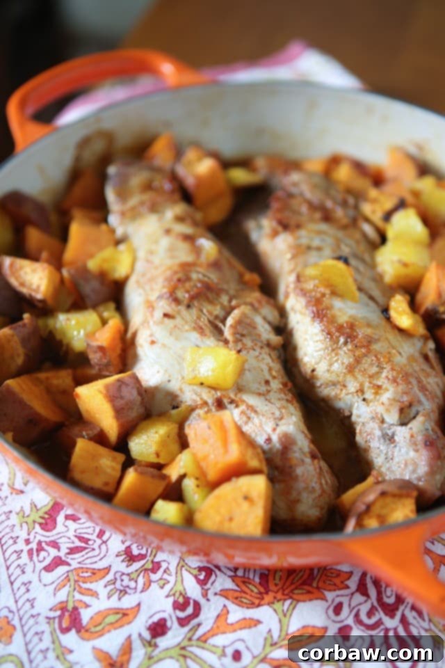 Close-up of Maple Mustard Roasted Pork Tenderloin with Sweet Potatoes and Mango showing tender meat and caramelized vegetables.