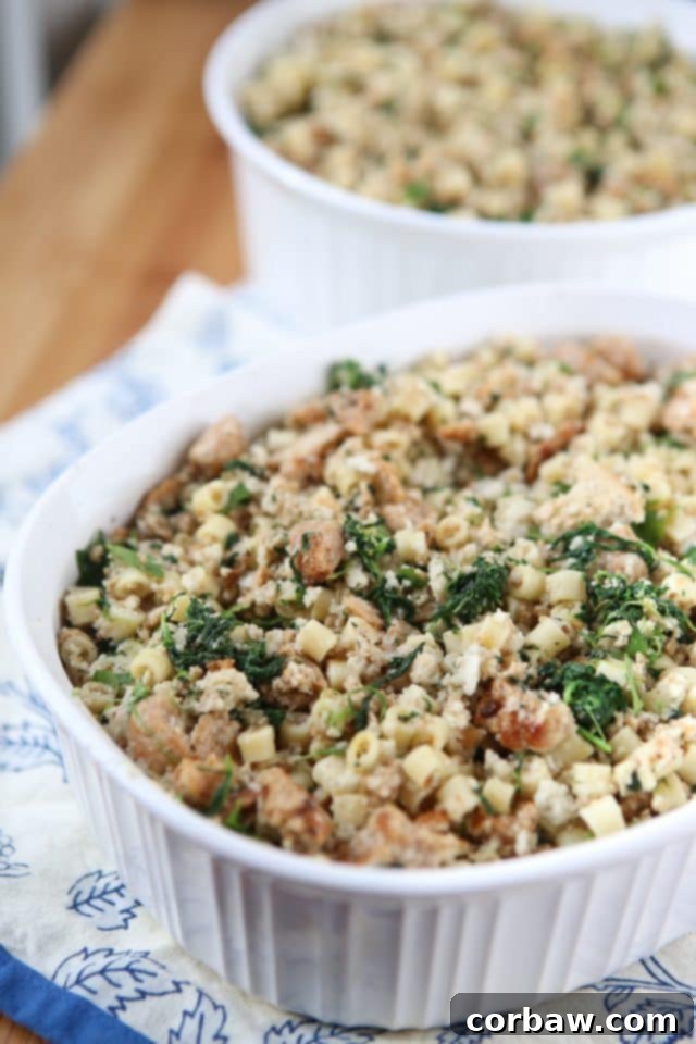 A close-up view of the rich, golden-brown Italian-style stuffing in a Corningware baking dish, featuring crumbled sausage, pasta, and vibrant spinach.