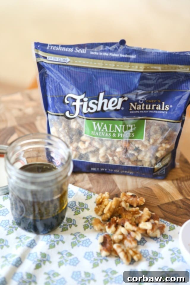 package of Fisher walnut halves and pieces on a cutting board alongside dressing in a mason jar and a handful of the walnuts