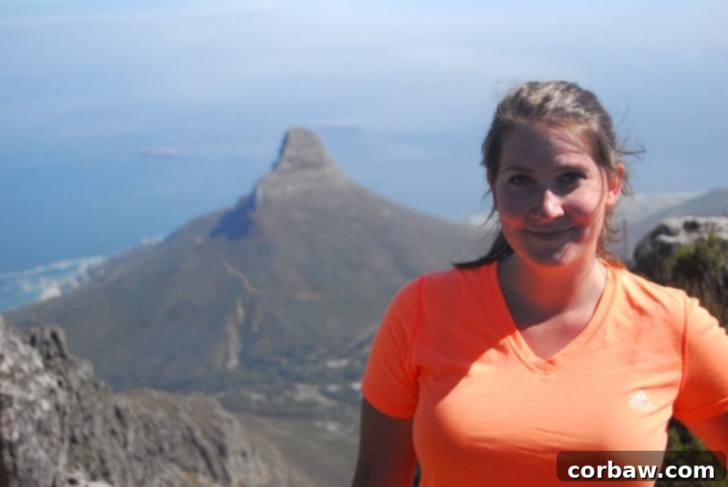 Person on top of a rock formation on Table Mountain, showcasing personal achievement
