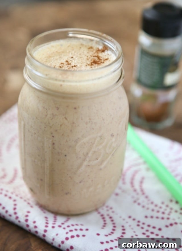 Freshly blended Peach Pie Smoothie with peaches and oats on a wooden surface